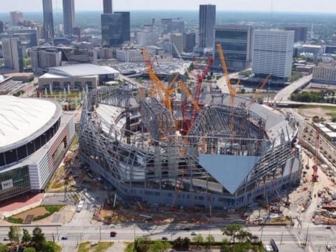 A large building under construction with many cranes.