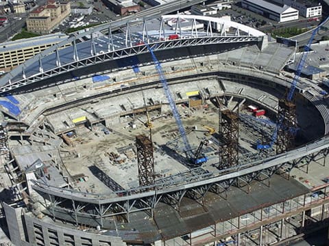 A construction site with many cranes and scaffolding.