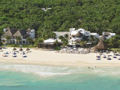 A beach with many umbrellas and some people on it